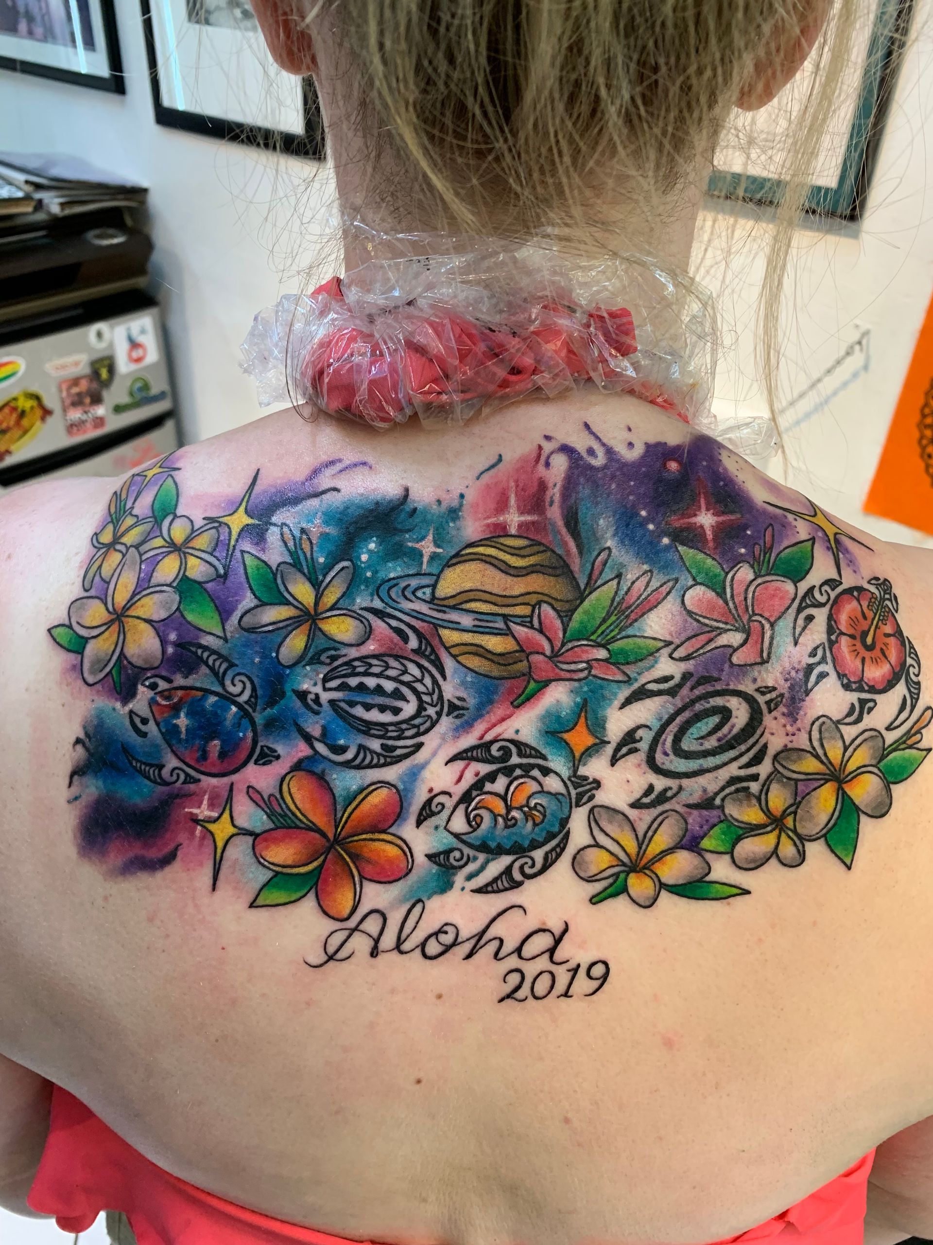 A woman has a tattoo on her back that says aloha 2019