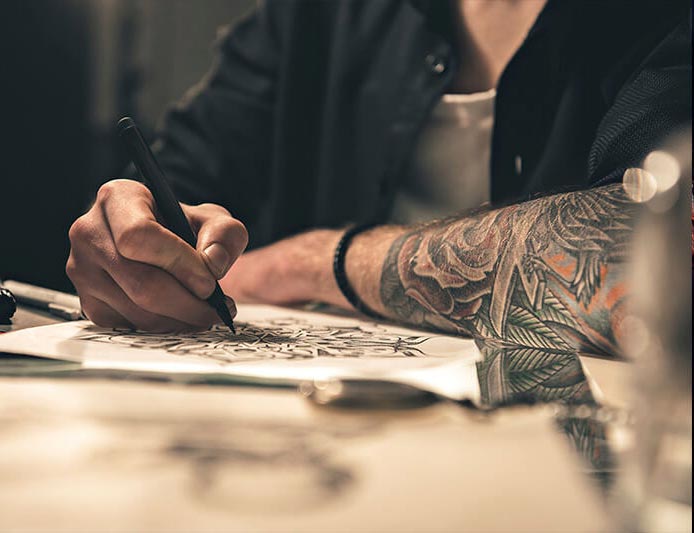 Tattoo artist sketching a custom design at Aloha Tattoo in Waikiki, Hawaii