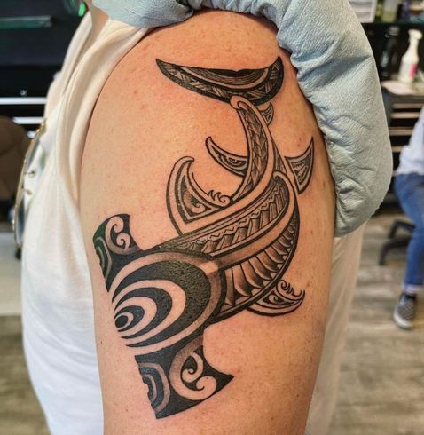 A man has a tattoo of a shark on his arm