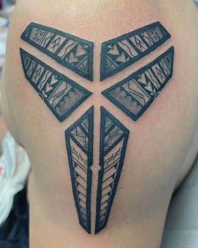 A person has a tattoo on their back that looks like a basketball logo