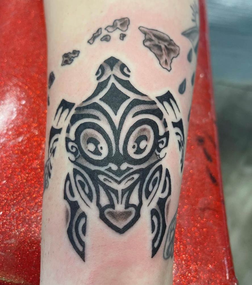 A person has a tattoo of a turtle on their arm