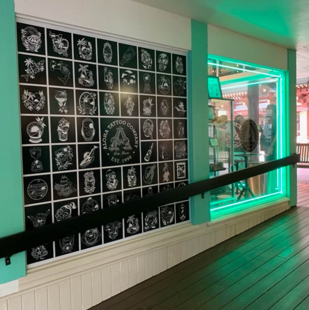 A wall with a lot of pictures on it and the word tattoo on it