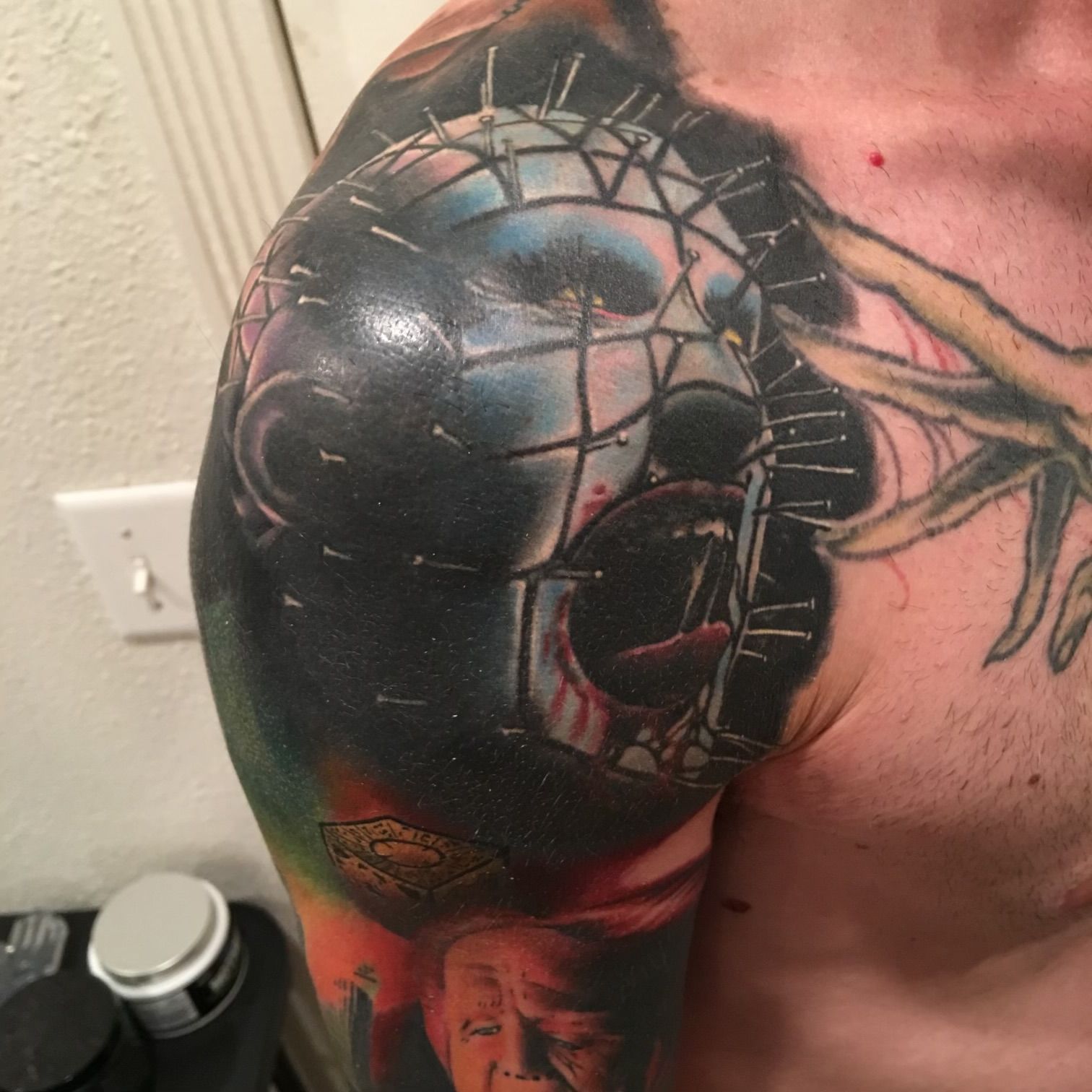 A man has a tattoo of a skull on his shoulder