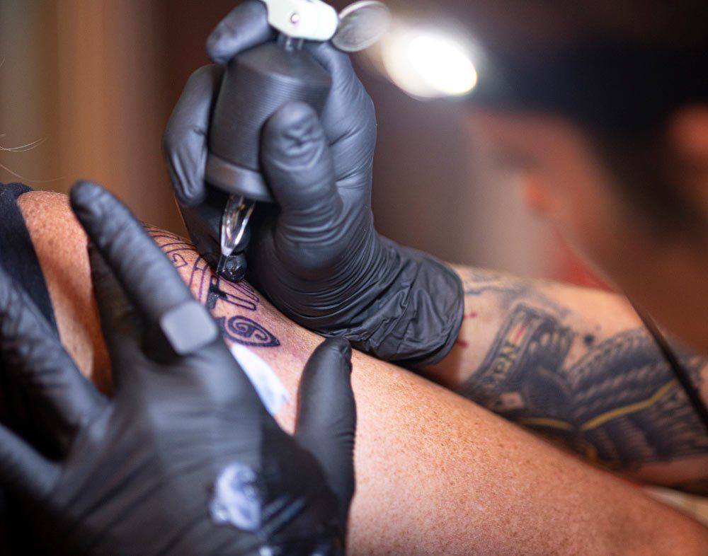 A person is getting a tattoo on their arm.