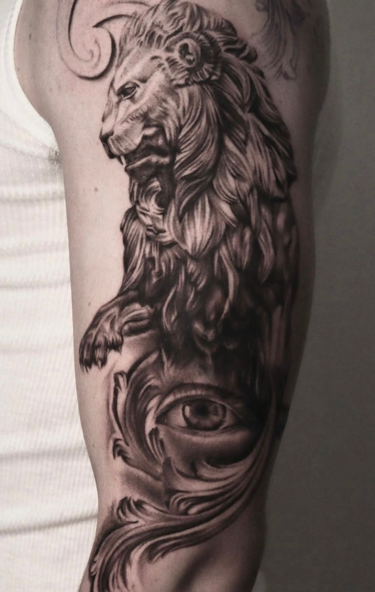 Detailed realism tattoo of a fierce lion and ornamental eye—black and grey artistry by guest tattoo artist at Aloha Tattoo Waikiki near Hilton Hawaiian Village, Honolulu