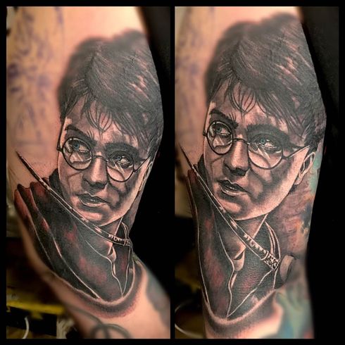 A black and white tattoo of harry potter on a person 's arm.