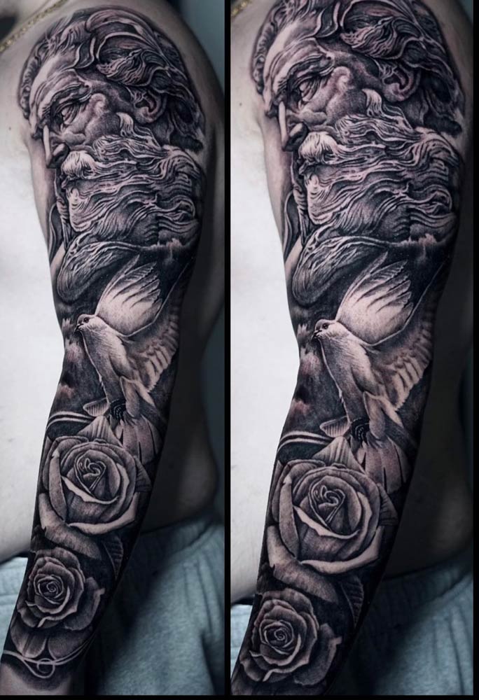 A black and white tattoo of a man with birds and roses on his arm.