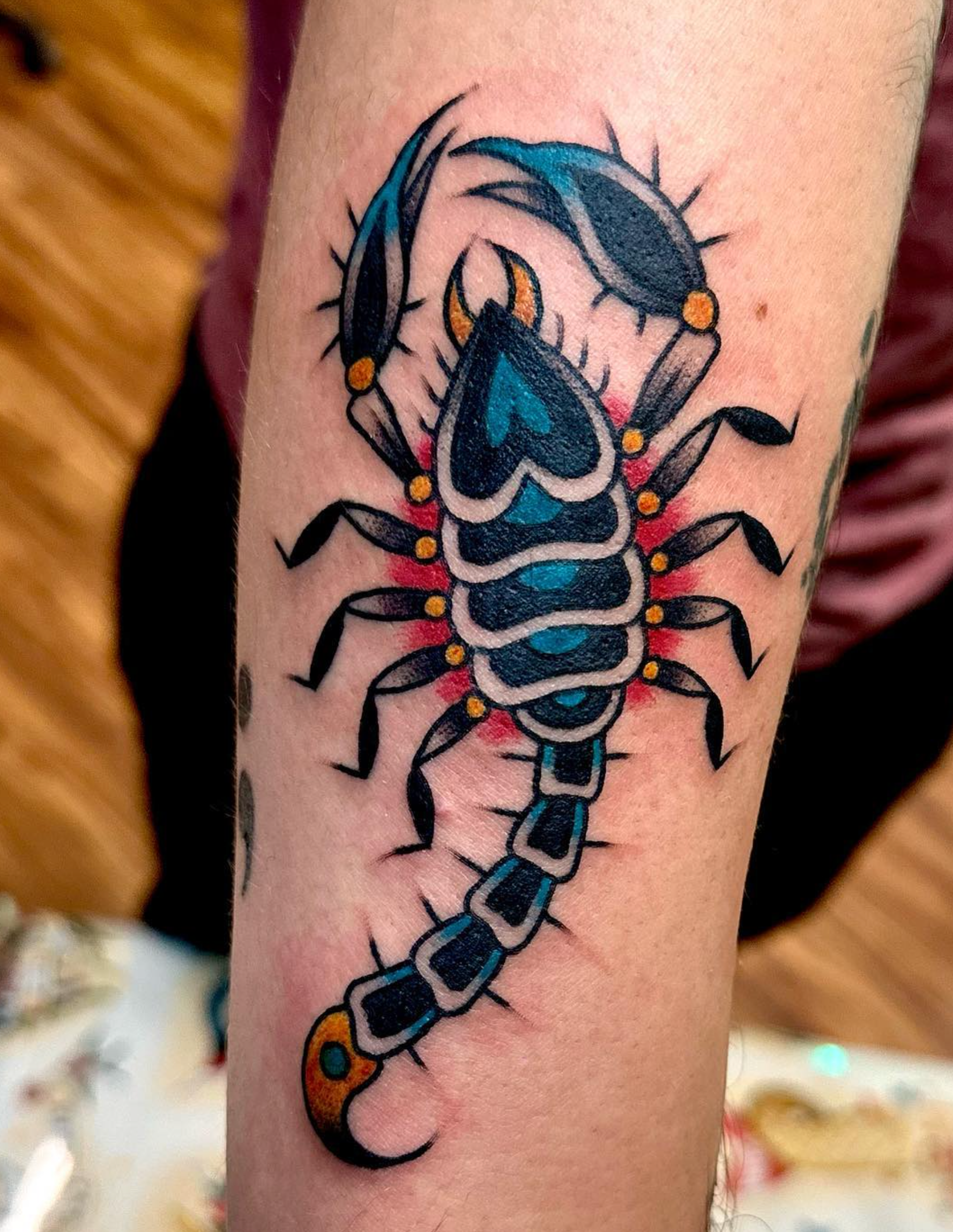 A person has a tattoo of a scorpion on their arm