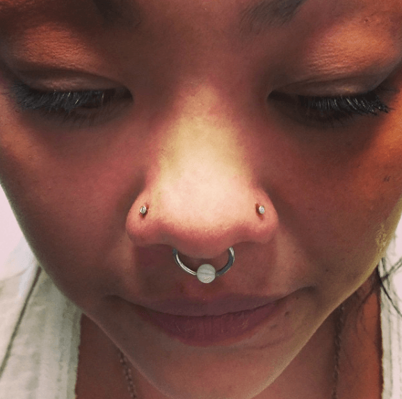 A close up of a woman 's nose with a nose ring.