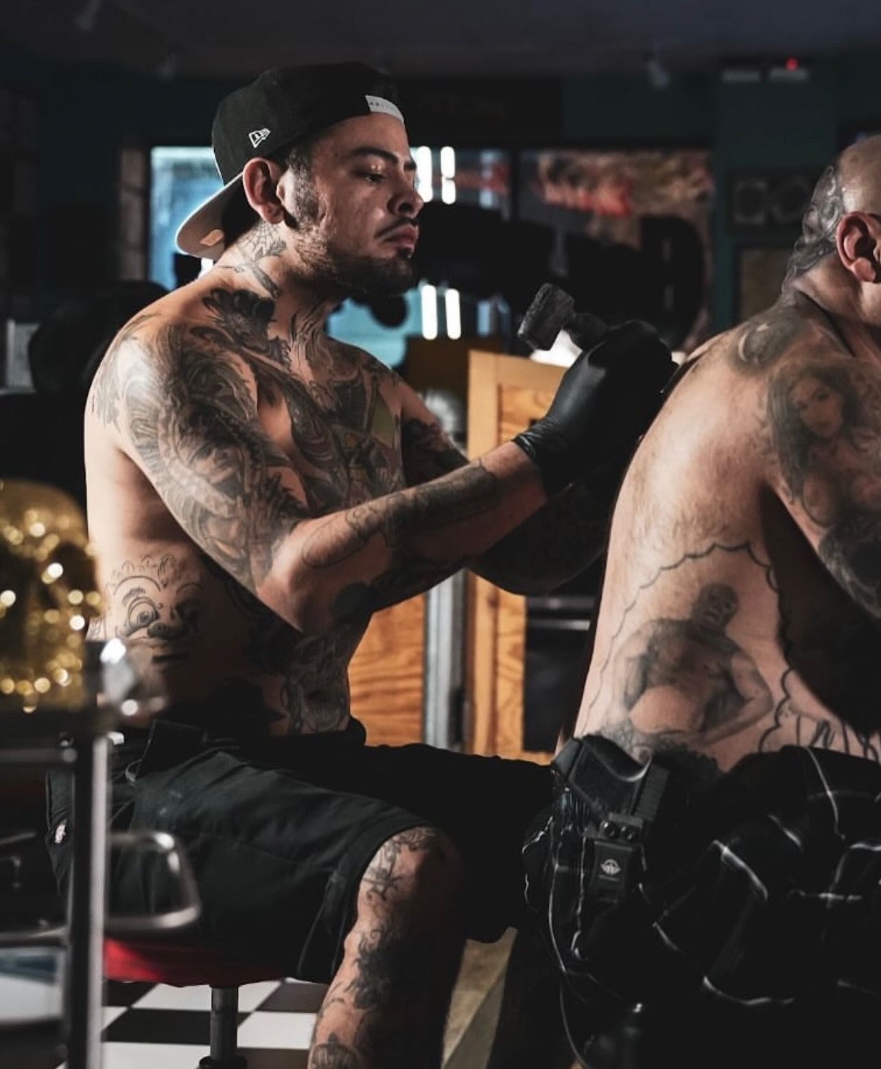 Tattoo artist Ricky Pantera at Waikiki studio captured mid-session as he inks a detailed back.