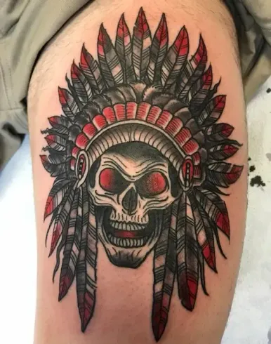 Traditional skull tattoo with red feathered headdress and bold shading