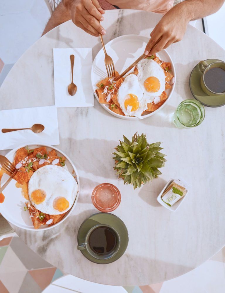 A person is sitting at a table eating fried eggs