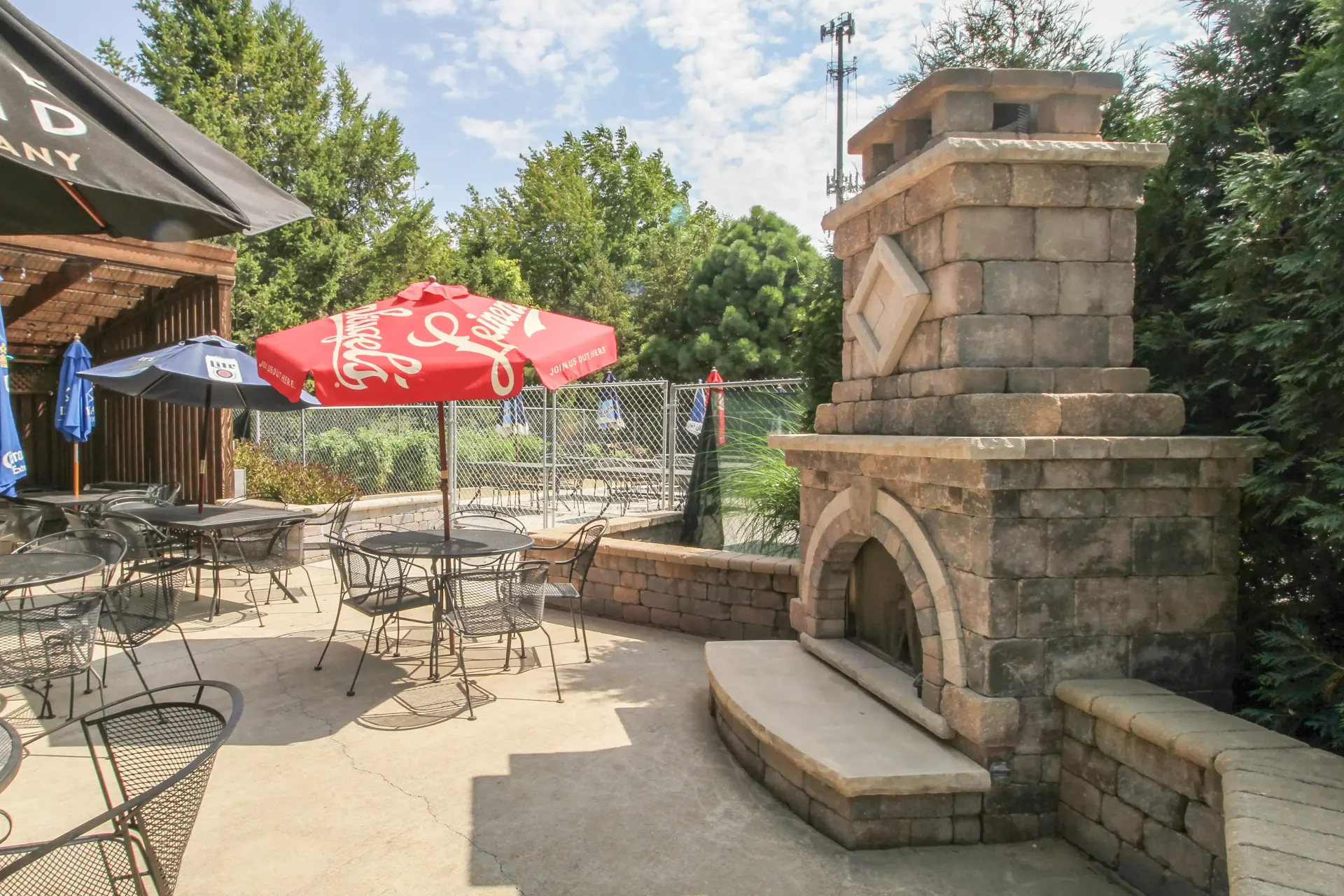 A patio with tables and chairs and a fireplace