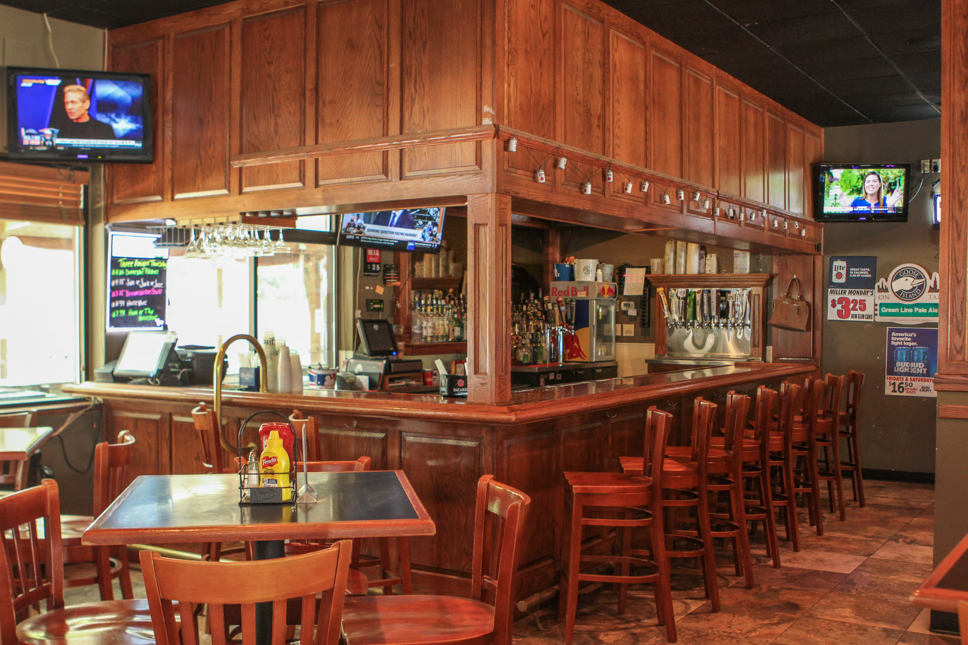 A restaurant with a long bar and tables and chairs