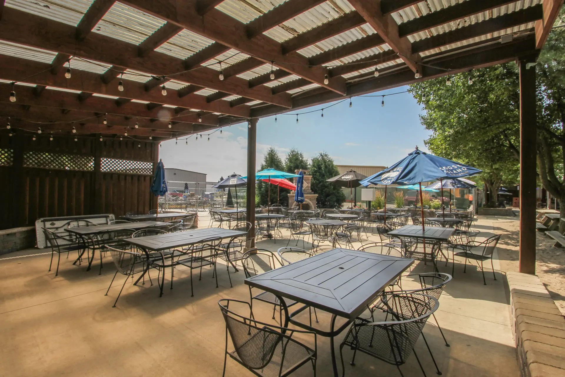A patio with tables and chairs under a pergola