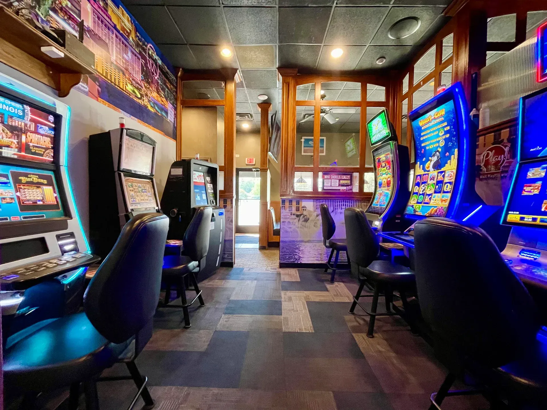 A room filled with lots of gaming machines and chairs.