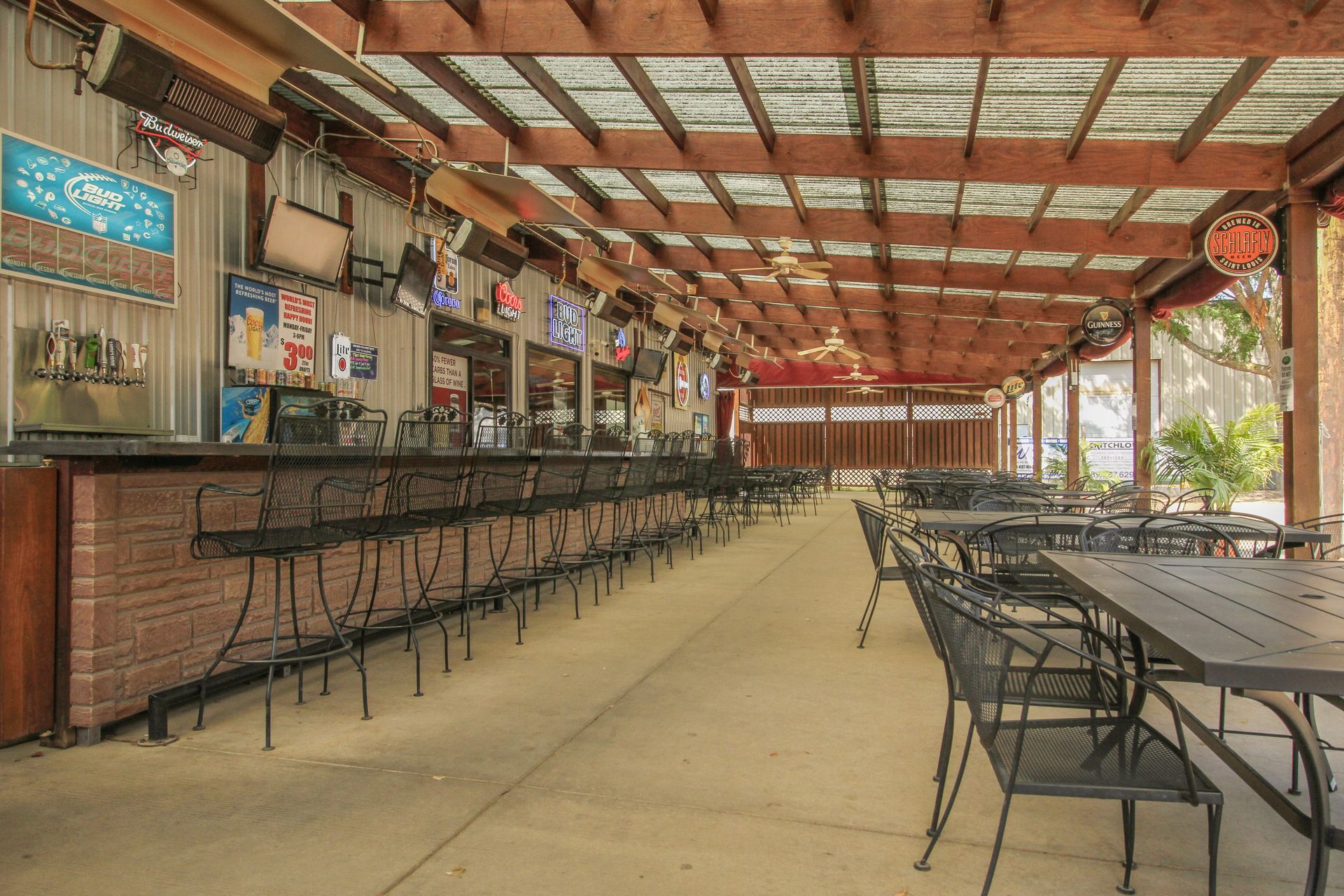 A restaurant with tables and chairs under a covered roof.