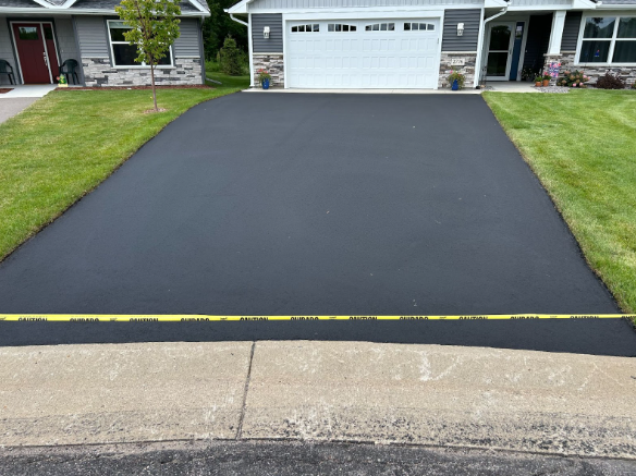 A house with a black driveway and a white garage door