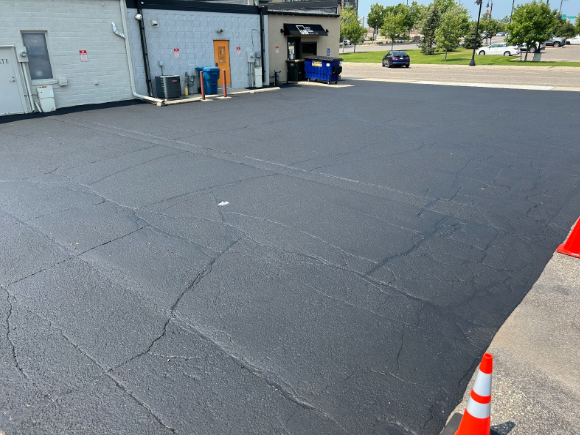 A parking lot with a car parked in front of a building.