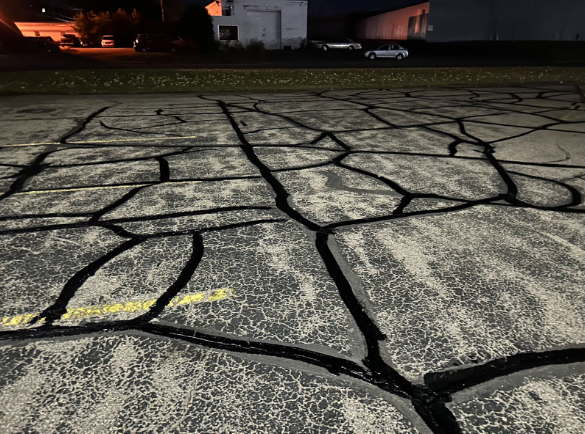 A concrete driveway with a geometric pattern painted on it at night.