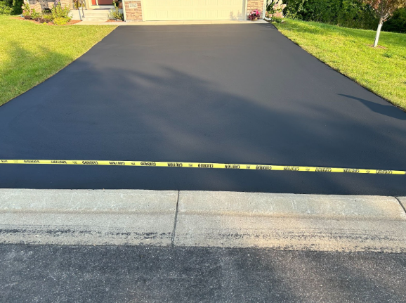 A black driveway with yellow tape on the curb