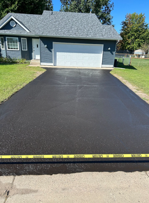 A house with a gray roof and a black driveway
