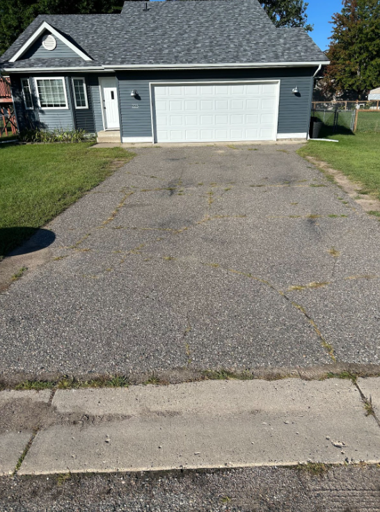 A house with a garage and a driveway in front of it.