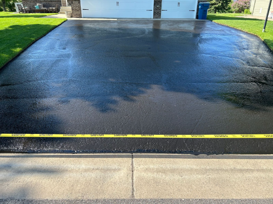 A black asphalt driveway with a yellow line in the middle