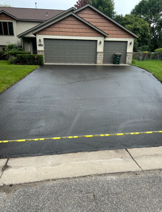 A driveway leading to a house with two garage doors