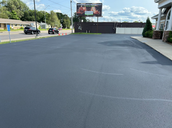 A car is parked in a parking lot next to a building.