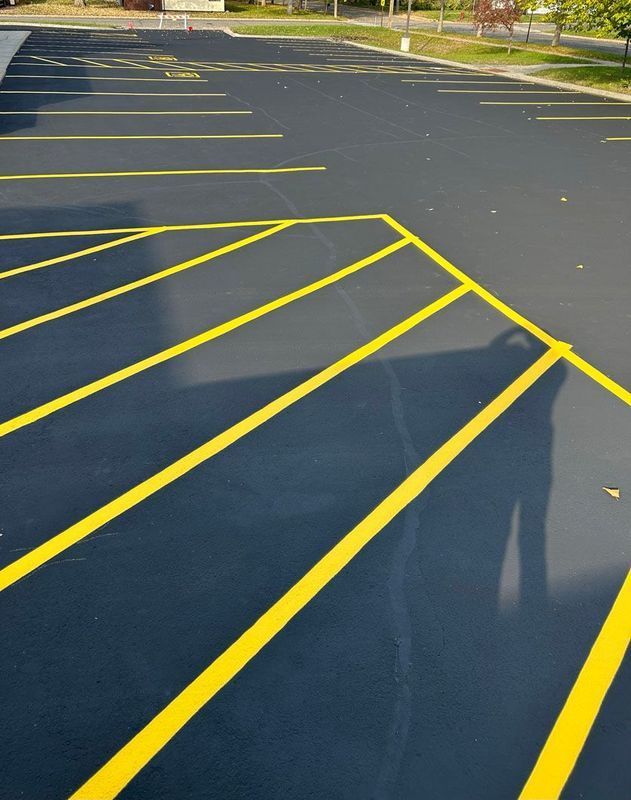 A parking lot with yellow lines and a shadow of a person