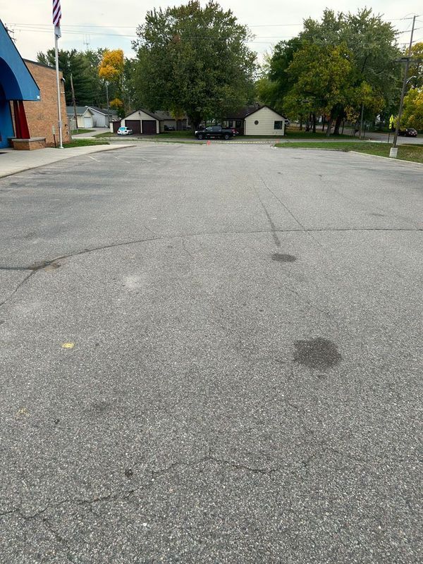 An empty parking lot with a blue building in the background