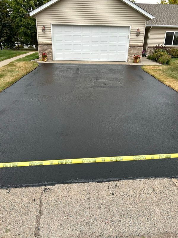 A driveway in front of a house with a white garage door.