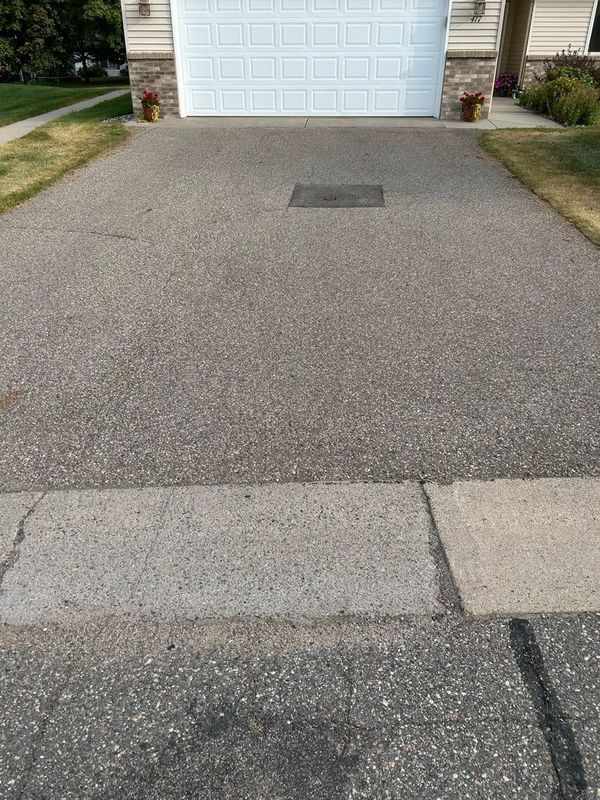 A driveway leading to a garage with a white garage door.