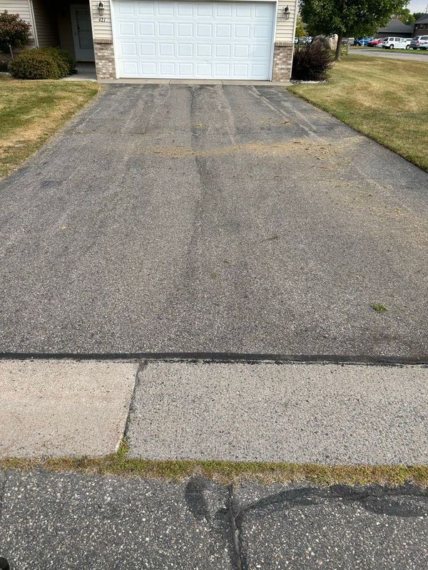 A driveway leading to a house with a white garage door.