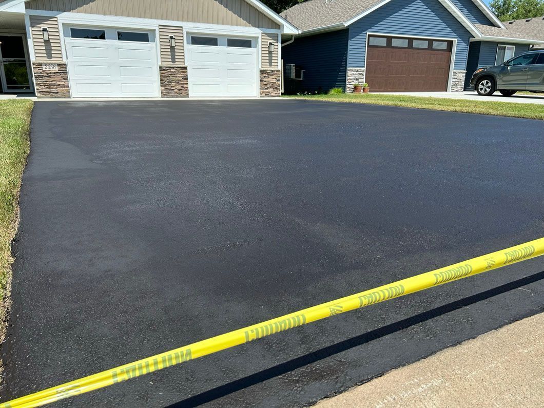 A car is parked in a driveway next to a house.