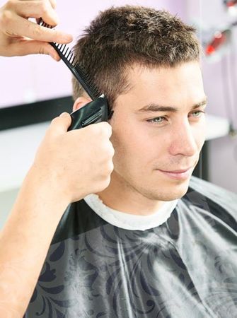 a male client getting his hair cut done