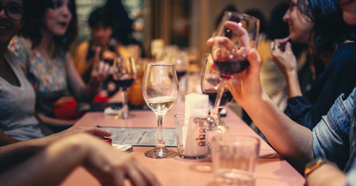 Un groupe de personnes sont assises à une table et boivent du vin.