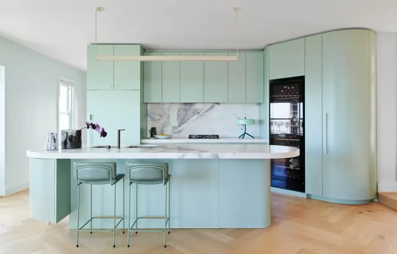 A kitchen with mint green cabinets and a large island.