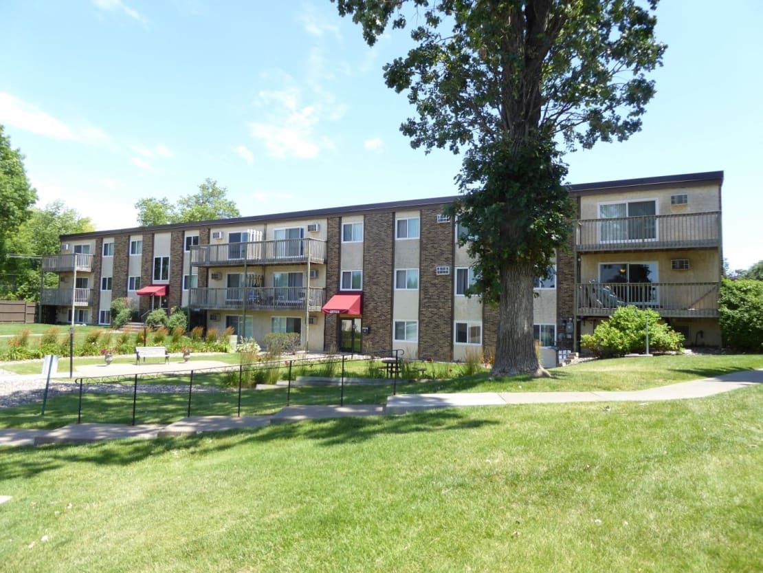 A large apartment building with a tree in front of it