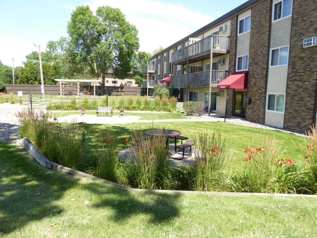 A large apartment building with a picnic table in front of it.
