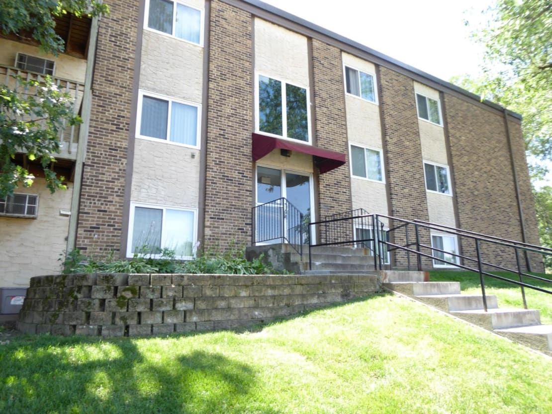 A large brick apartment building with stairs leading up to it