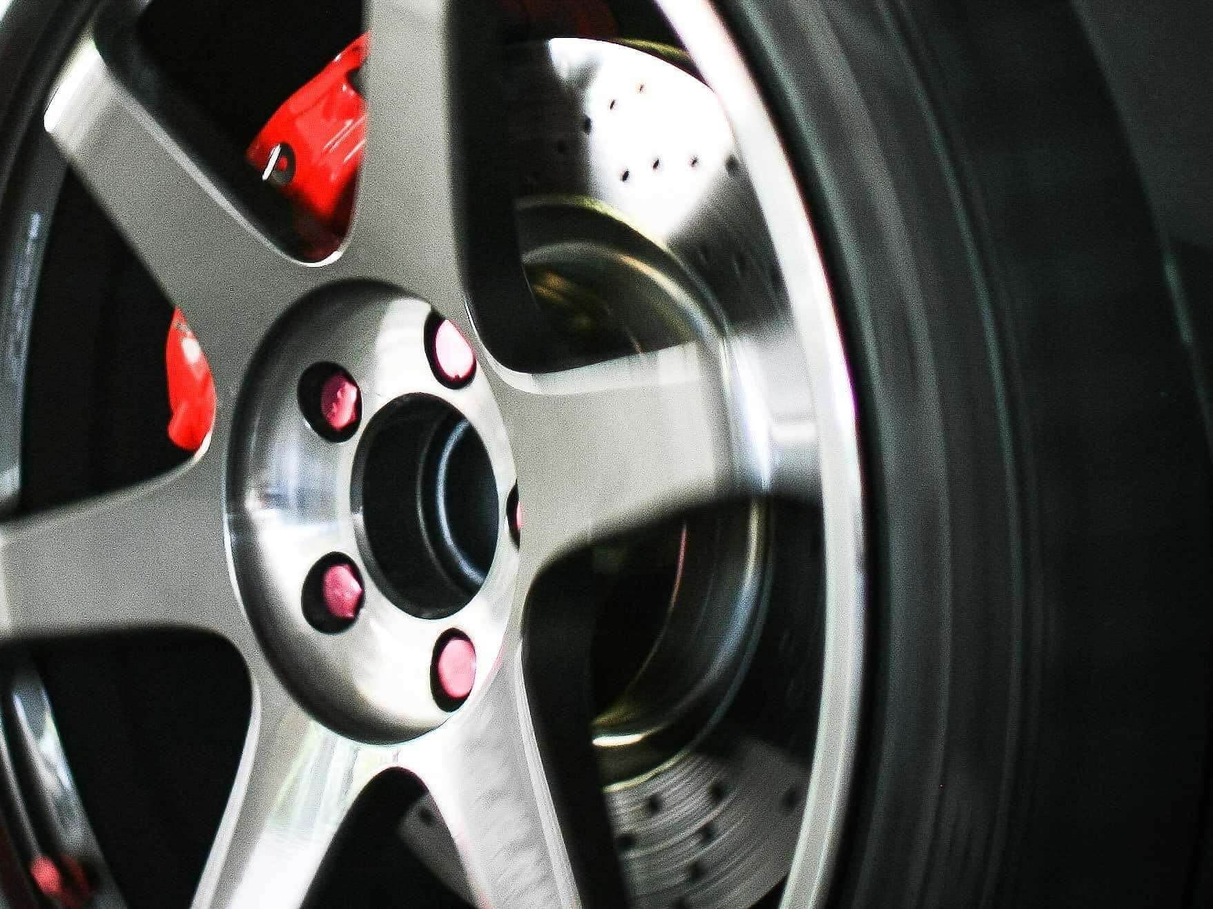 A close up of a car wheel with red brake calipers | Doctor of Motors