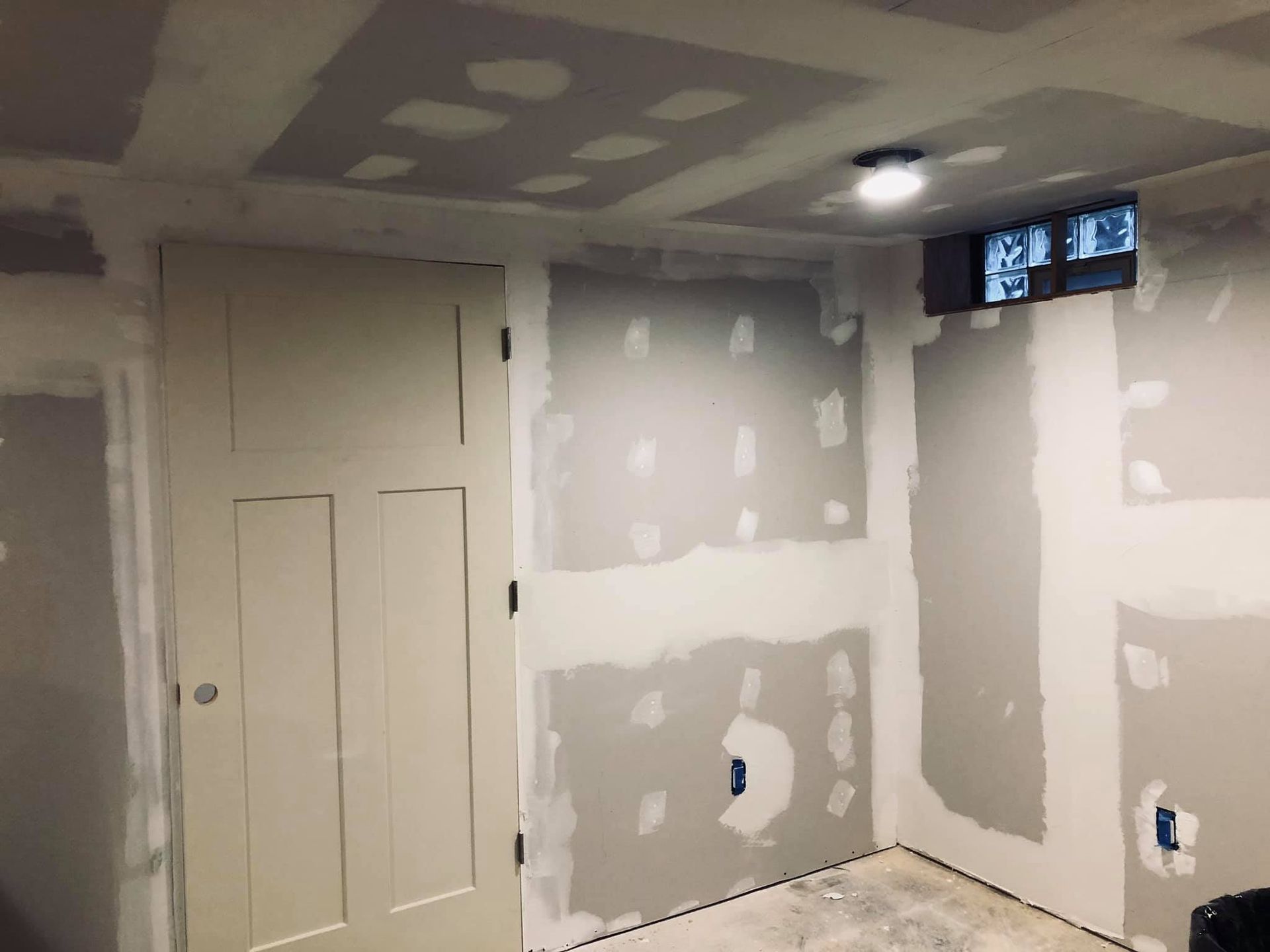 A renovation project featuring a newly installed black and white staircase in a basement with exposed ceiling and tools.