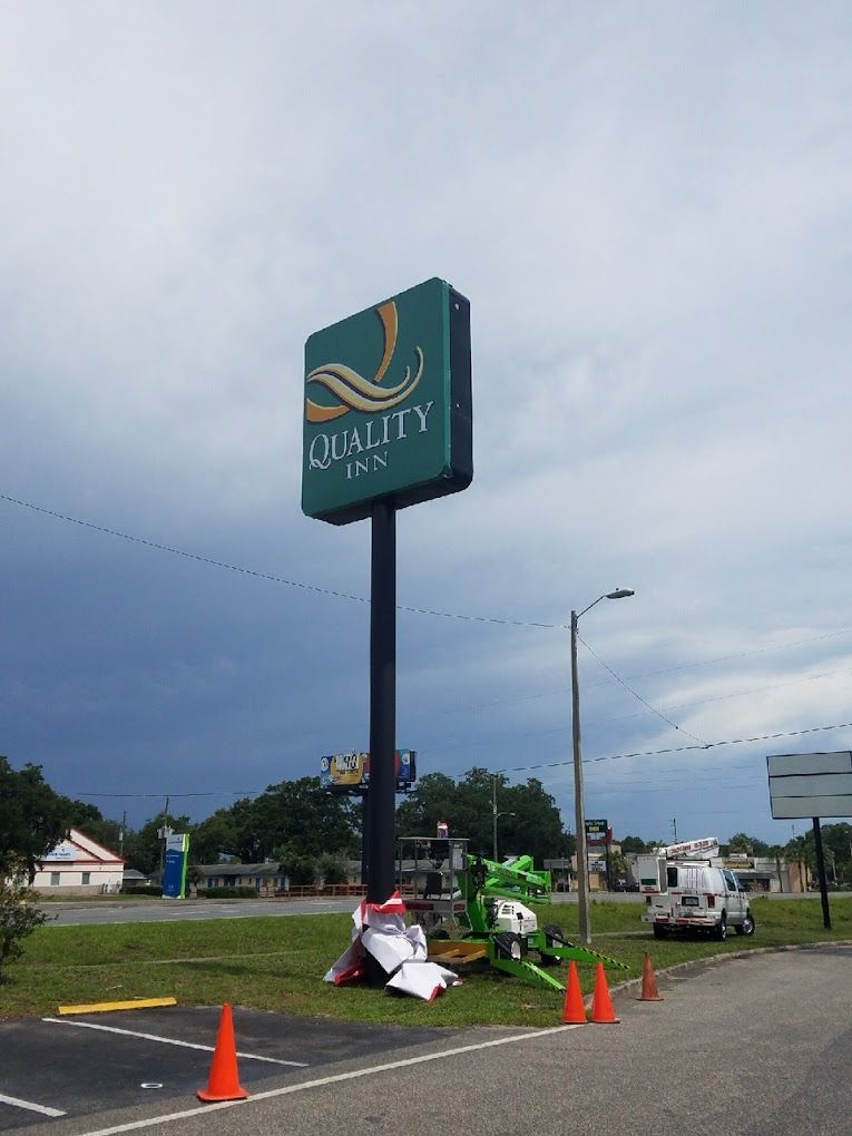 A green sign that says quality inn on it