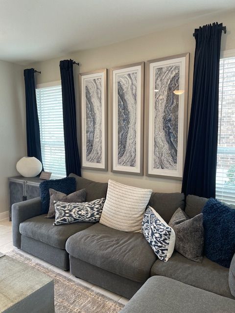 A living room with a couch and three pictures on the wall