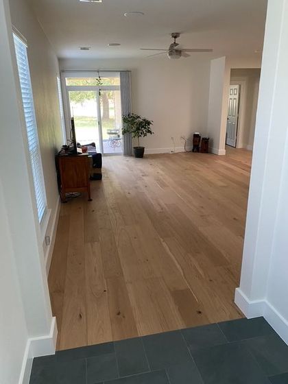 A living room with hardwood floors and a ceiling fan.