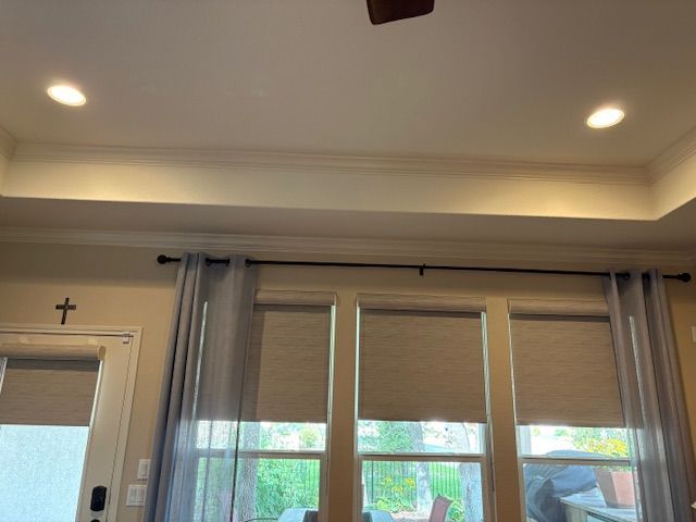 A living room with a ceiling fan and a cross on the wall.