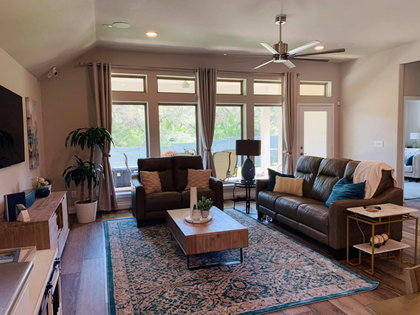 A living room filled with furniture and a ceiling fan.