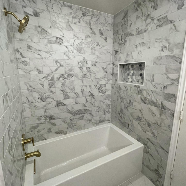 A bathroom with marble walls and a bathtub